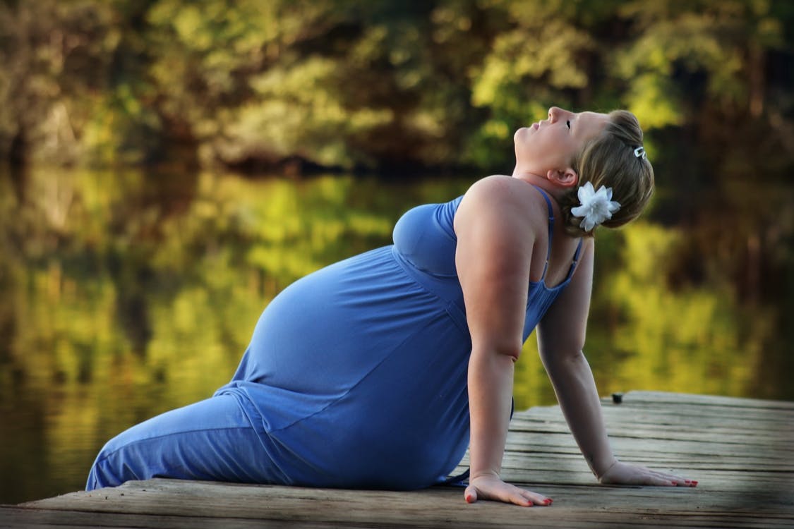 Pregnant Woman Sitting on Brown Wooden Dock